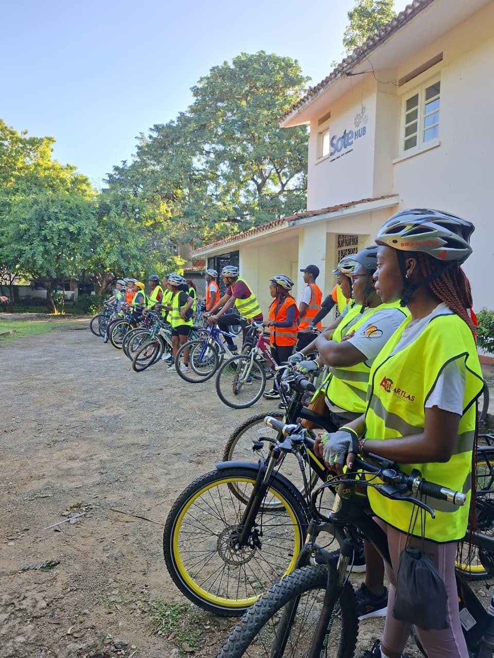 A line of girls in hi-vis vests with their bikes outside Sote Hub
