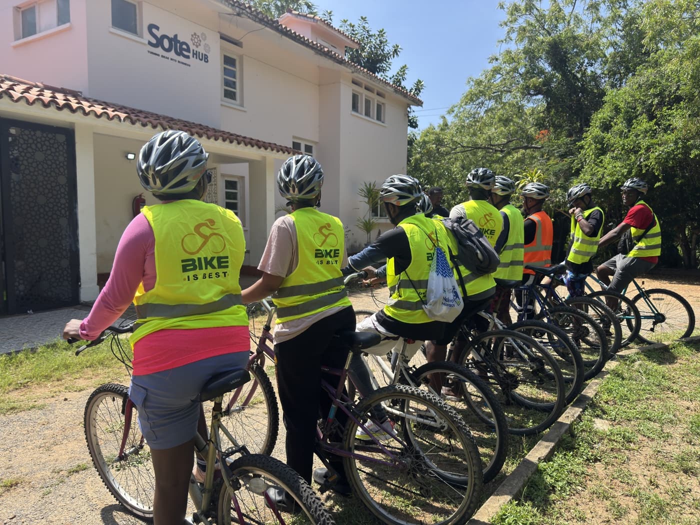 Riders in hi-vis vests lined up with their bikes outside Sote Hub before setting off