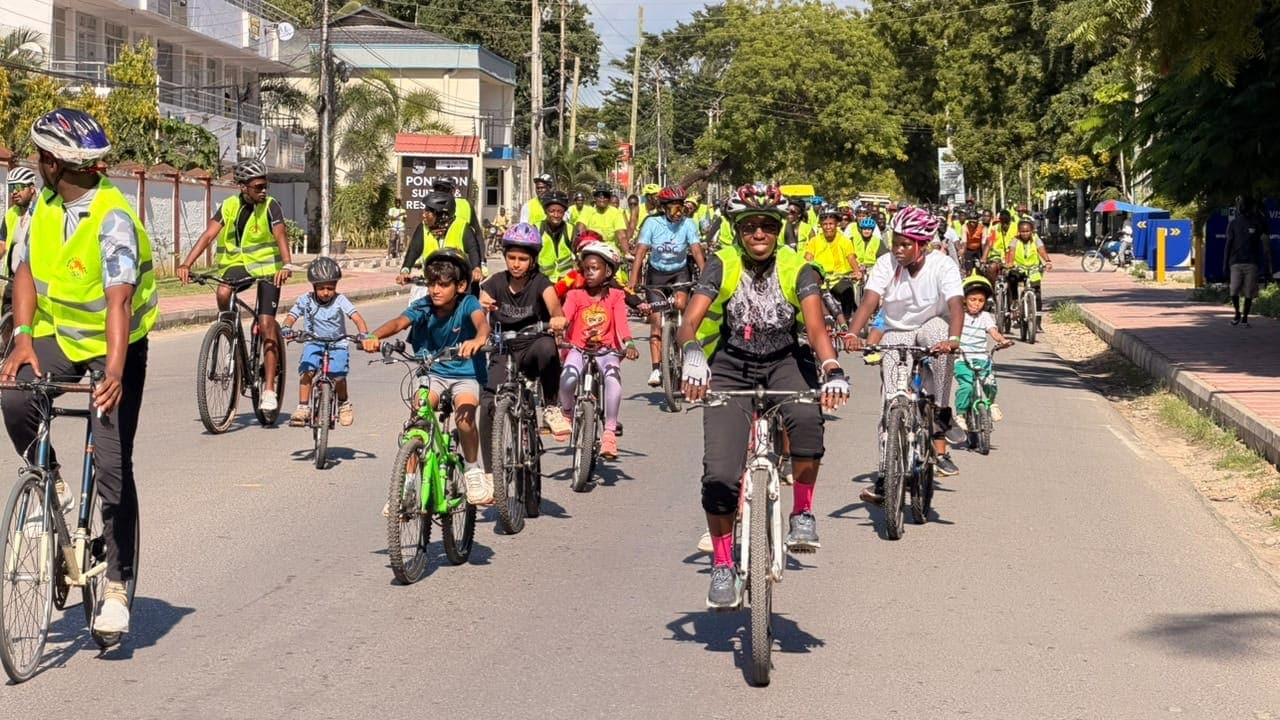 Riders of all ages, including young children, cycling down a Nyali street on World Bicycle Day