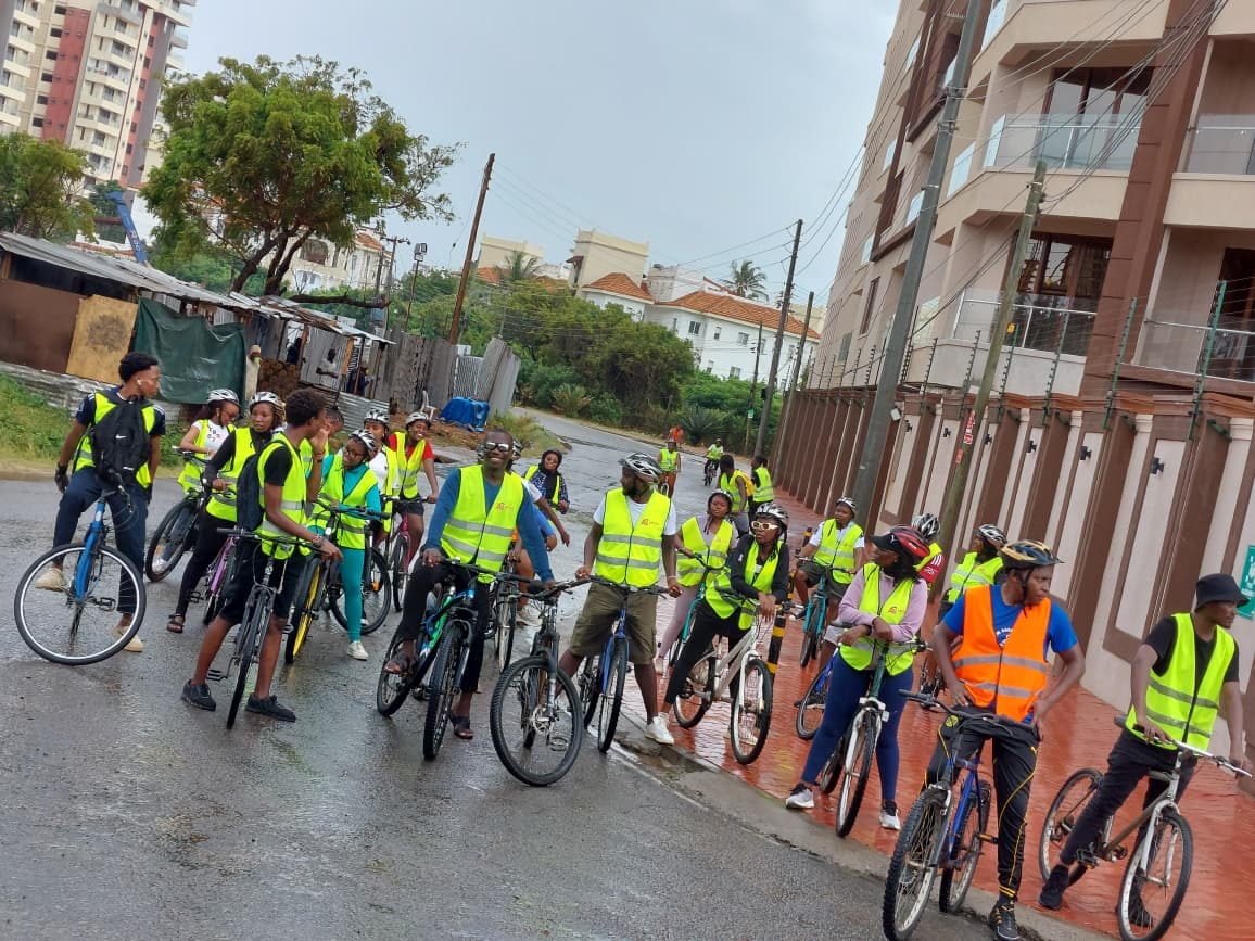 Riders in hi-vis vests lined up with their bikes on a Nyali street before the ride